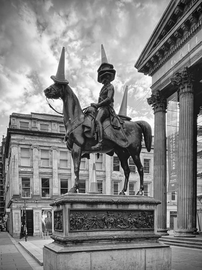 Horse and cones, 2023 The equestrian statue of Arthur Wellesley, 1st Duke of Wellington, situated outside the Royal Exchange, now referred to as the Gallery of Modern Art in Glasgow, Scotland, stands as one of the city's most iconic landmarks. Sculpted by Italian artist Carlo Marochetti, it was erected in 1844 following public subscription to commemorate the successful conclusion in 1815 of the lengthy French Revolutionary Wars and the Napoleonic Wars. Since at least the 1980s, it has been humorously adorned with a traffic cone by members of the public. 2023 Glasgow