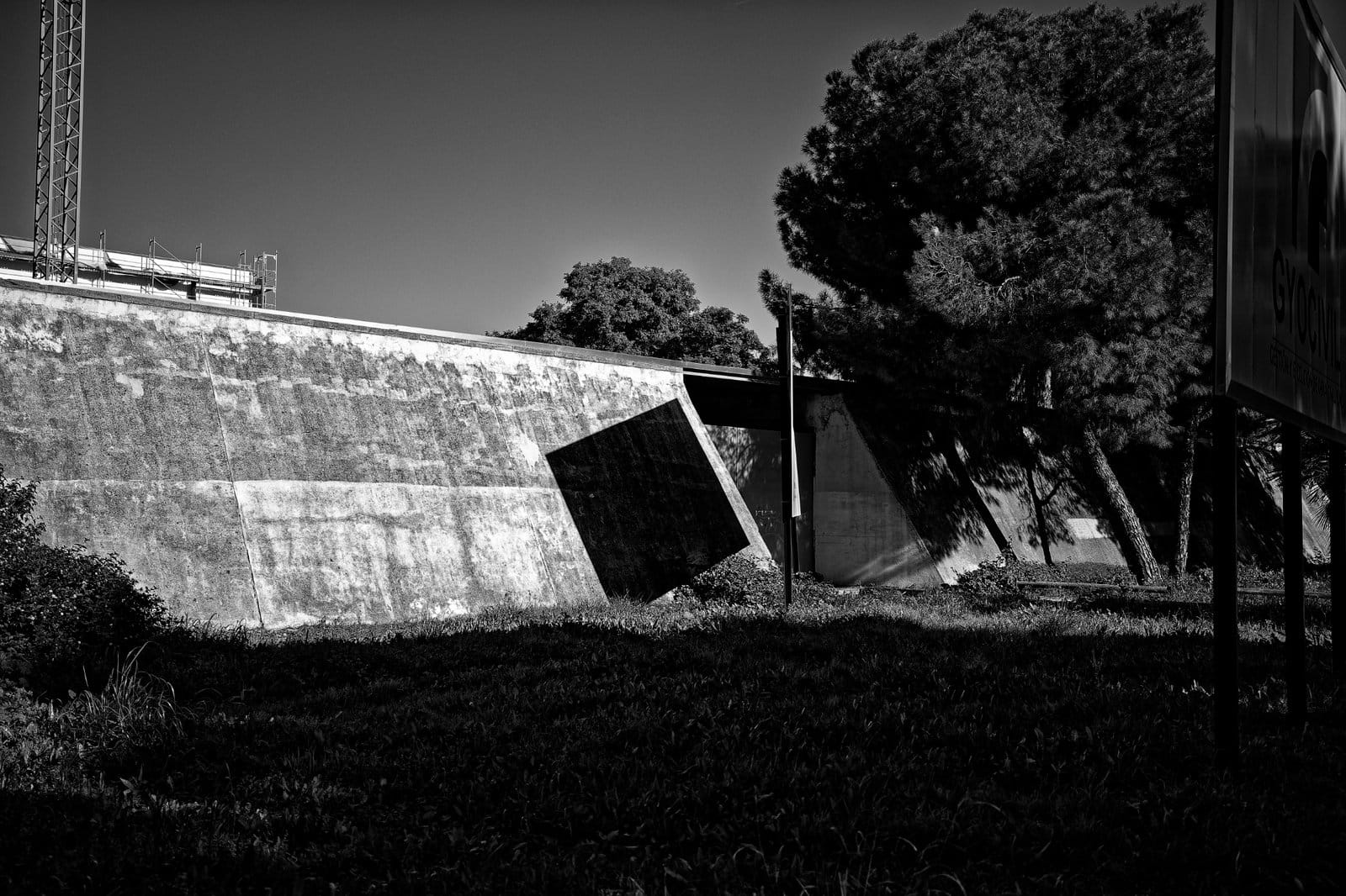 A billboard castign a shadow on a concrete wall in Seville Spain, 2024